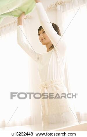 Housewife spreading table cloth View Large Photo Image Stock Photo - Housewife spreading table cloth. Fotosearch