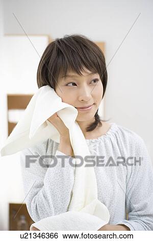 Stock Photograph - Housewife wiping face with towel. Fotosearch