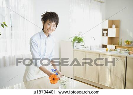 Young woman arranging flower View Large Photo Image Stock Image - Young woman arranging flower. Fotosearch