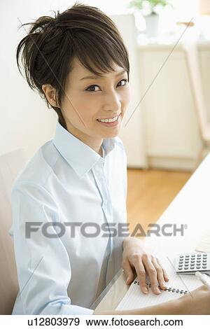 Stock Photo - Young woman calculating. Fotosearch