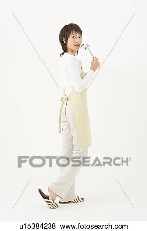 Stock Photo - Young woman holding ladle. Fotosearch