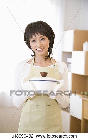 Young woman holding pan View Large Photo Image Stock Image - Young woman holding pan. Fotosearch