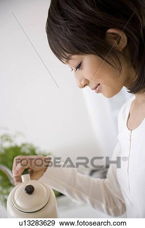 Young woman pouring coffee View Large Photo Image Stock Photo - Young woman pouring coffee. Fotosearch