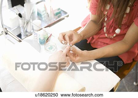 Beautician applying artificial nail View Large Photo Image Stock Image - Beautician applying artificial nail. Fotosearch