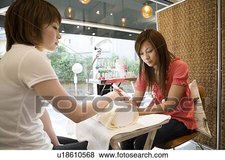 Beautician filing nails View Large Photo Image Stock Photo - Beautician filing nails. Fotosearch