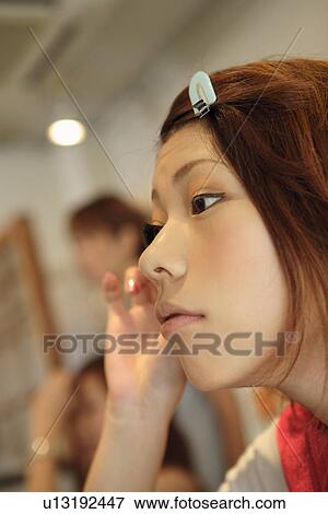 Young woman applying make up View Large Photo Image Stock Photo - Young woman applying make up. Fotosearch