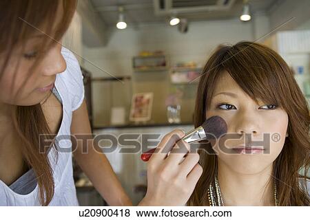 Stock Photo - Young woman applying make up. Fotosearch