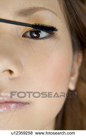 Young woman applying mascara View Large Photo Image Stock Photo - Young woman applying mascara. Fotosearch