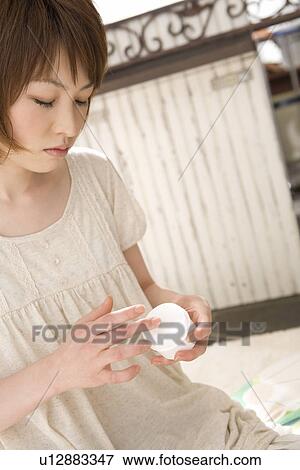 Stock Photo - Young woman applying moisturizer. Fotosearch