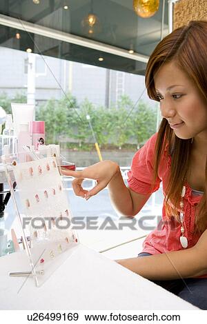 Young woman choosing artificial nails View Large Photo Image Stock Photo - Young woman choosing artificial nails. Fotosearch