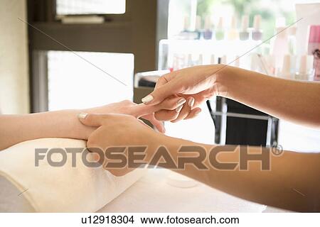 Picture - Young woman massaging fingers. Fotosearch