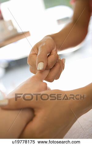 Stock Photography - Young woman massaging fingers. Fotosearch