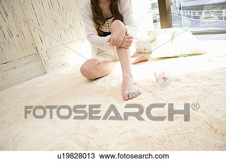 Young woman painting toe nails View Large Photo Image Stock Image - Young woman painting toe nails. Fotosearch