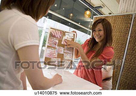 Young woman talking with beautician at nail salon View Large Photo Image Stock Photography - Young woman talking with beautician at nail salon. Fotosearch