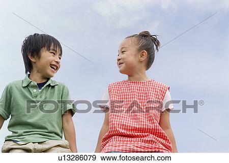 Boy and girl looking at each other View Large Photo Image Stock Photo - Boy and girl looking at each other. Fotosearch
