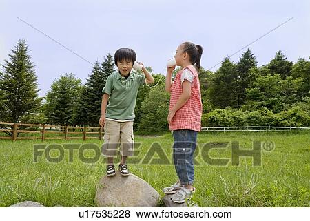 Stock Photo - Boy and girl talking with string telephone. Fotosearch