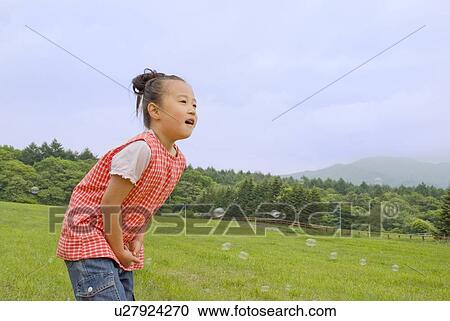 Stock Image - Children playing with bubble. Fotosearch