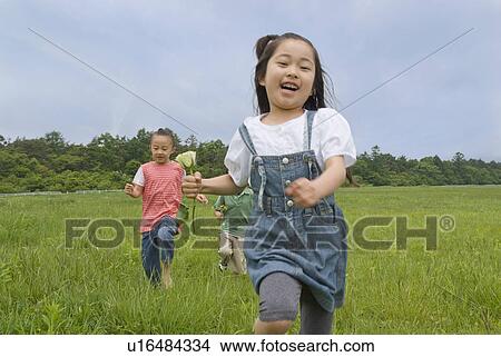 Picture - Children running on grass field. Fotosearch