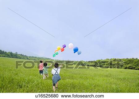 Stock Image - Children running with balloons. Fotosearch