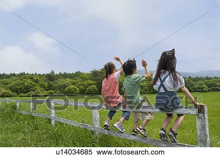 Children sitting on fence View Large Photo Image Stock Photography - Children sitting on fence. Fotosearch