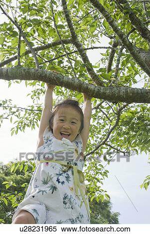 Stock Photography - Girl hanging from tree. Fotosearch