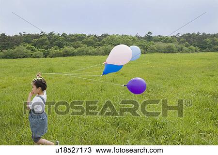 Stock Image - Girl holding balloons. Fotosearch