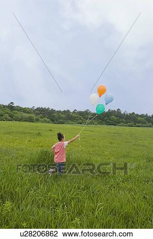 Girl holding balloons View Large Photo Image Stock Image - Girl holding balloons. Fotosearch