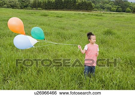 Girl holding balloons View Large Photo Image Stock Photograph - Girl holding balloons. Fotosearch