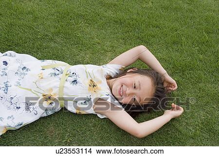 Picture - Girl lying on grass. Fotosearch