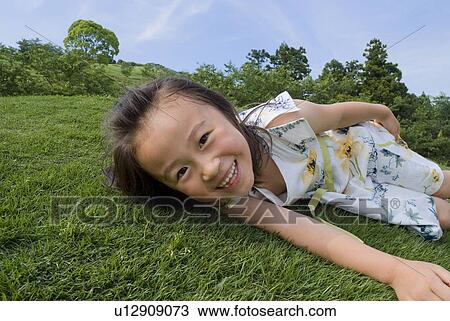 Girl lying on grass View Large Photo Image Stock Image - Girl lying on grass. Fotosearch