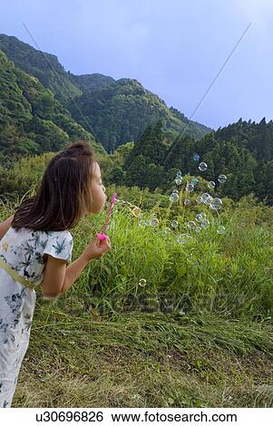 Girl playing with bubbles View Large Photo Image Stock Photograph - Girl playing with bubbles. Fotosearch