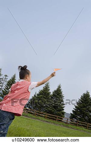 Stock Image - Girl playing with paper plane. Fotosearch