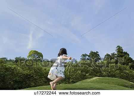 Picture - Girl running on grass field. Fotosearch