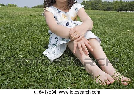 Picture - Girl sitting on grass. Fotosearch