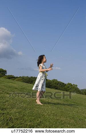 Stock Photograph - Girl standing on grass. Fotosearch