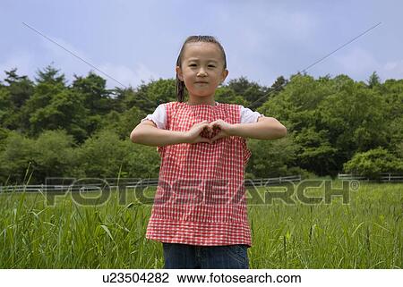 Portrait of a girl standing on grass field View Large Photo Image Stock Image - Portrait of a girl standing on grass field. Fotosearch
