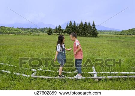Stock Photo - Two girls playing on grass field. Fotosearch