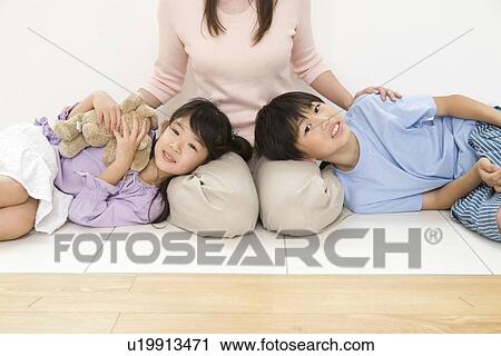 Stock Image - Children sleeping on mother's lap. Fotosearch