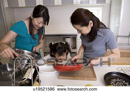 Family cooking in kitchen View Large Photo Image Stock Photograph - Family cooking in kitchen. Fotosearch