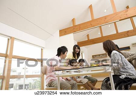 Family sitting at dining table View Large Photo Image Picture - Family sitting at dining table. Fotosearch