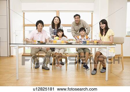 Family sitting at dining table View Large Photo Image Stock Image - Family sitting at dining table. Fotosearch