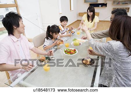 Family sitting at dining table View Large Photo Image Stock Image - Family sitting at dining table. Fotosearch
