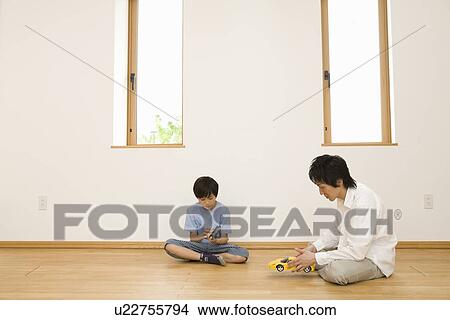 Picture - Father and son playing with toy car. Fotosearch