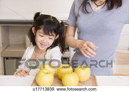 Girl looking at apples View Large Photo Image Stock Photo - Girl looking at apples. Fotosearch