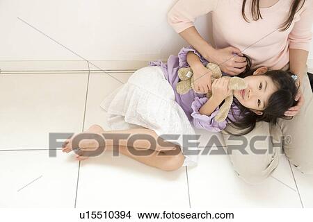 Picture - Girl sleeping on mother's lap. Fotosearch