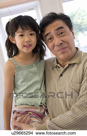 Picture - Grandfather holding granddaughter. Fotosearch