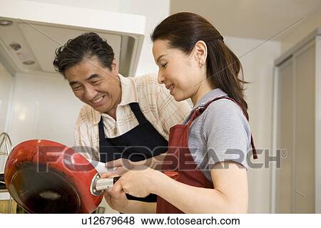 Stock Photo - Mature couple cooking in kitchen. Fotosearch