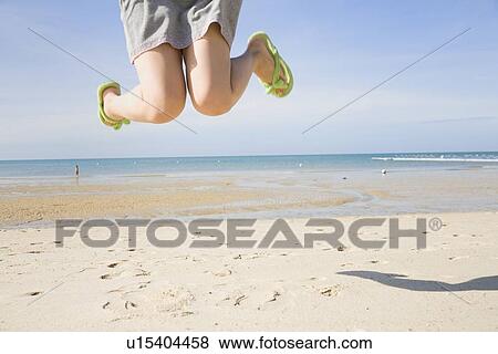 Legs of young woman jumping at beach View Large Photo Image Stock Photo - Legs of young woman jumping at beach. Fotosearch