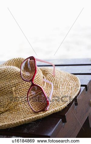 Stock Photo - Straw Hat and Sunglasses on deck chair. Fotosearch