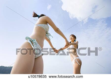 Two young women holding hands View Large Photo Image Stock Photography - Two young women holding hands. Fotosearch